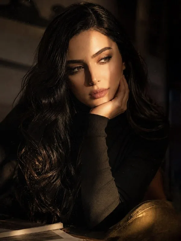 A cinematic portrait of a person is sitting in soft dramatic lighting. The face is partly