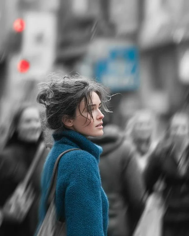 A cinematic street portrait of a young woman walking through a crowded city, with the subject