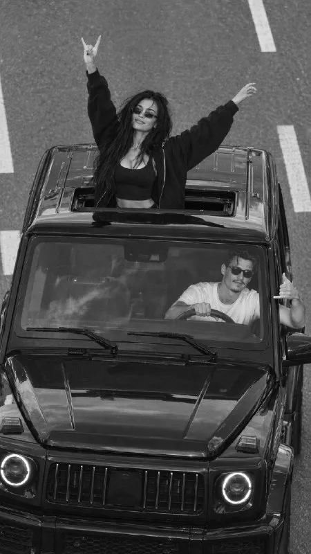 Vertical 9:16, ultra-photorealistic black-and-white documentary traffic-enforcement photograph, showing exactly two young adults in one coherent integrated