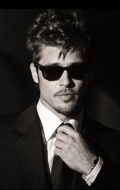 close-up, centered portrait of a young man with curly black hair, wearing black sunglasses, black sus,