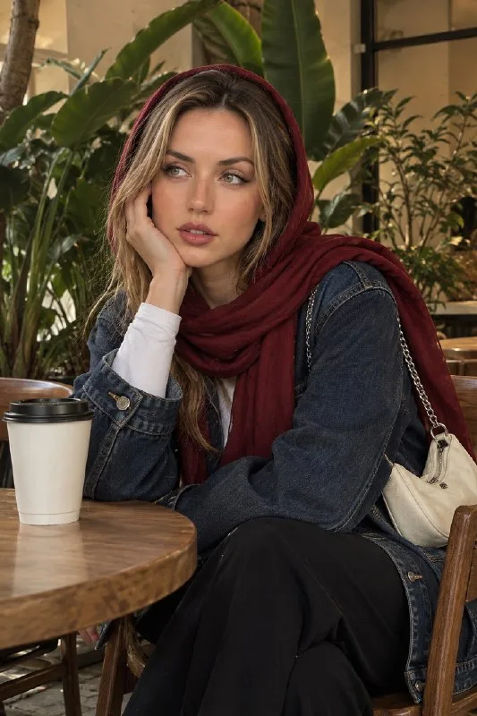 Photorealistic editorial portrait of a young woman sitting at a cozy modern café table, wearing a