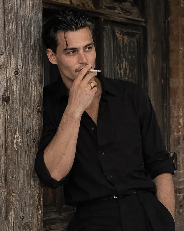 Vertical Mid-Shot Portrait (4:5): Man with a Cigarette Leaning Against an Old Wooden Post.