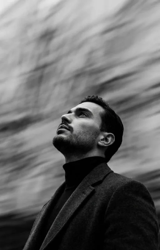 A cinematic, high-contrast black and white photograph captured from a sharp low-angle perspective, focusing on a